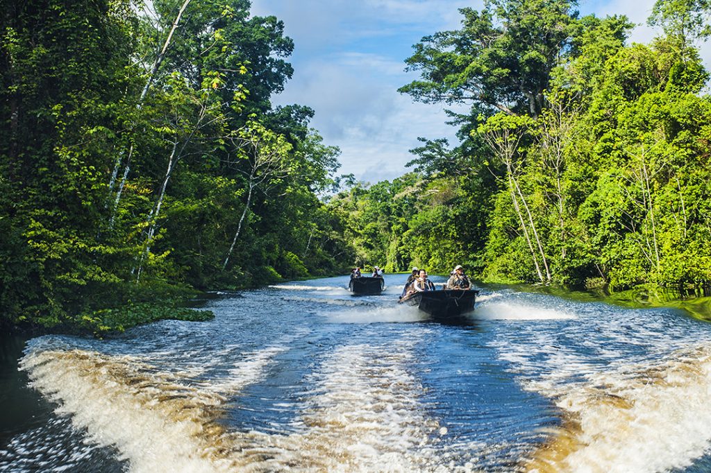 Two small boats sail down the Amazon river, on an excursion from Aqua Expeditions