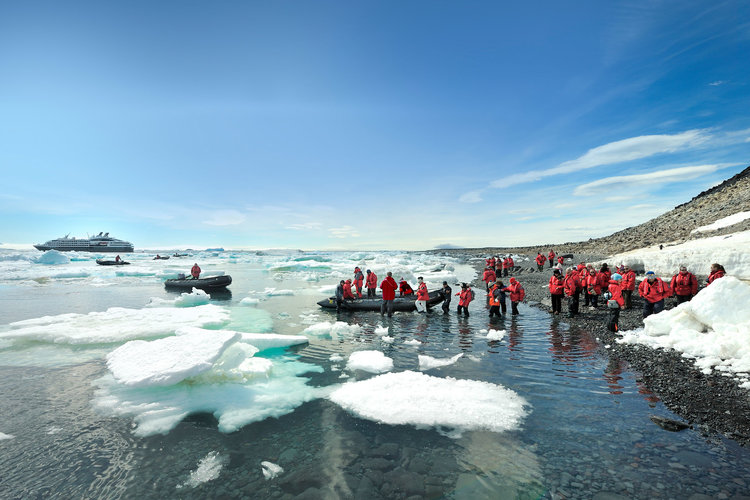 Zodiacs transporting people to shore excursions in Antarctica. Ponant ship can be seen in background.