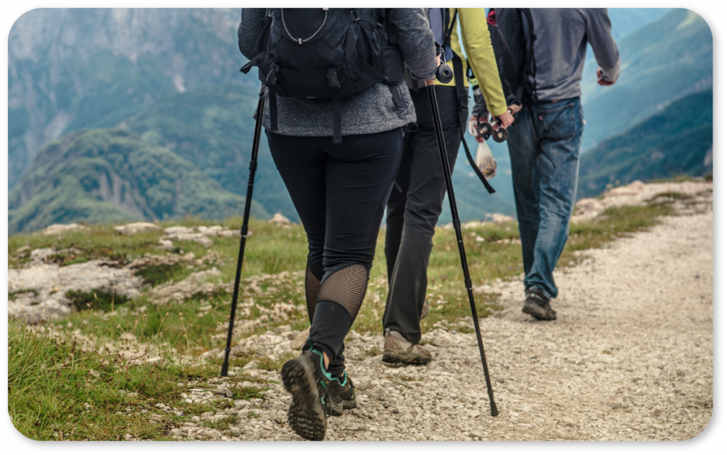 three people hiking with walking poles